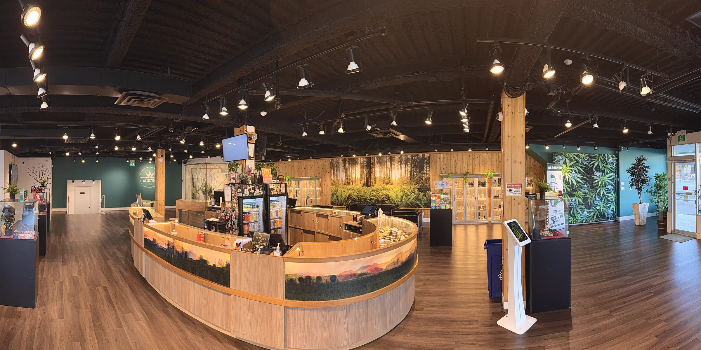Inside WestCanna Broadway: the round cedar counter with its painted mountain mural, the cabinets and the forest wall