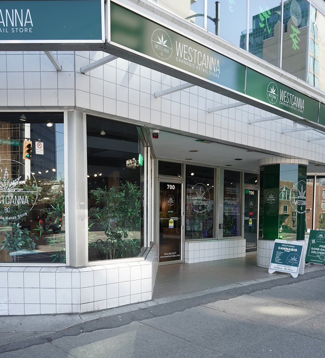 The Broadway corner store at 700 West Broadway: white tile, a deep-green fascia with the WESTCANNA sign and the round emblem, plants in the window.