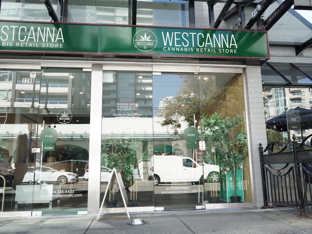 The WestCanna BC store at 1286 Robson Street: a green sign over glass frontage with planters. No person is in frame.